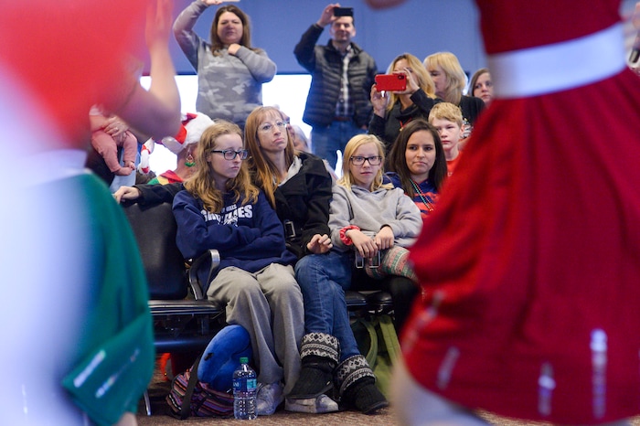 (Leah Hogsten | The Salt Lake Tribune) l-r Kalli Blamires, her mother Kimberly and sister Danika watch a dance troupe before boarding their flight. Ten Gold Star families from Salt Lake City were treated to a Winter Wonderland scene, including Whoville and the Grinch at their boarding gate at Salt Lake International Airport, Dec. 7, 2019 before their flight to Disney World aboard the Snowball Express. This month, the Gary Sinise Foundation's Snowball Express will fly more than 1,700 family members of fallen U.S. military heroes to Disney World for a holiday retreat.