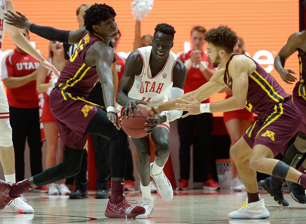 (Francisco Kjolseth  |  The Salt Lake Tribune)  Utah guard Both Gach (11) fights for the ball with Minnesota forward Isaiah Ihnen (35) and guard Gabe Kalscheur (22) in the Utes' 73-69 victory last Friday at the Huntsman Center.