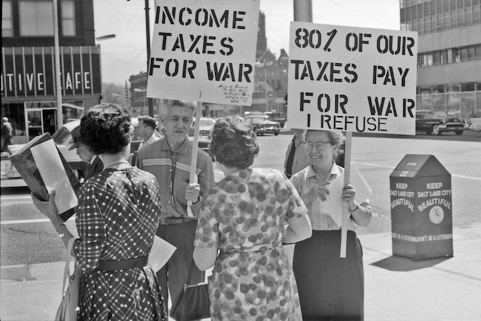 (photo courtesy Jerry Currier)  Ammon Hennacy and Carol Gorgen speak to passersby at the corner of 400 S Main in downtown Salt Lake City as they protest paying taxes in 1961 because as pacifists they were opposed to funding the military. 