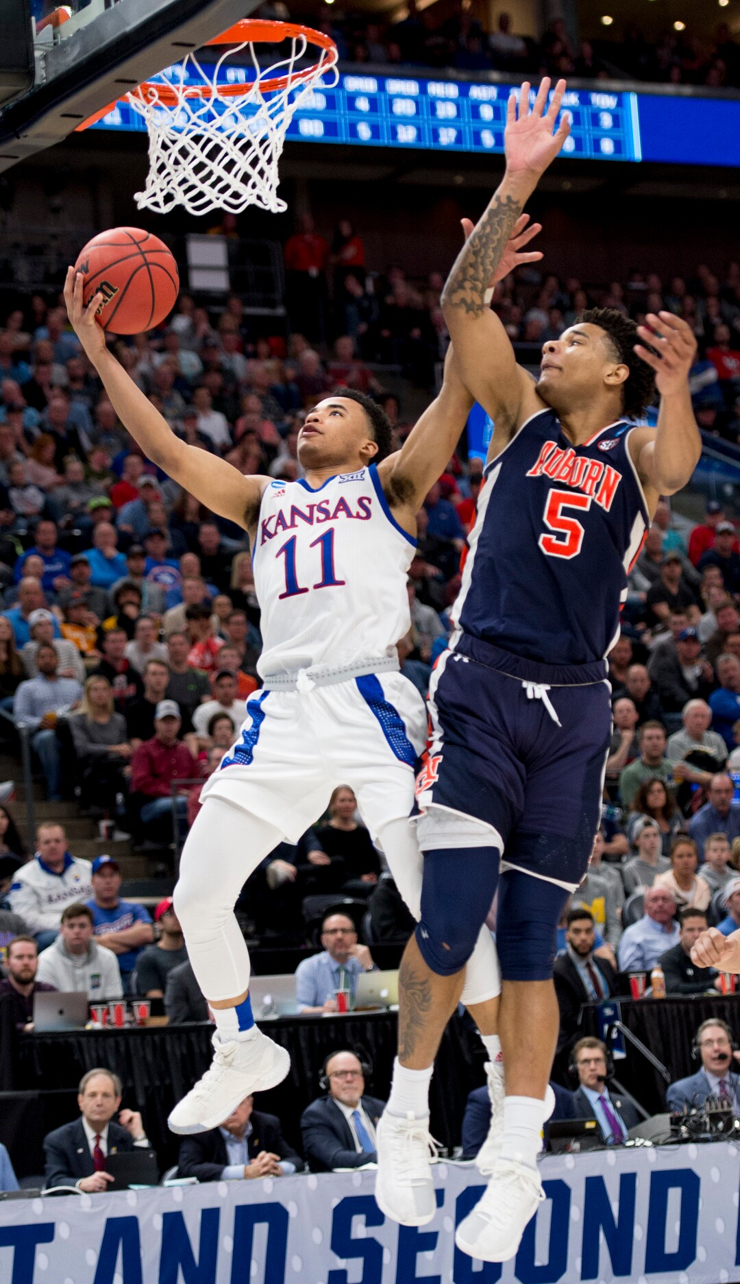 (Leah Hogsten  | The Salt Lake Tribune)  Kansas Jayhawks guard Devon Dotson (11) drives to the basket under pressure from Auburn Tigers forward Chuma Okeke (5) as Auburn faces Kansas in the second round of the NCAA tournament in Salt Lake City on Saturday, March 23, 2019.