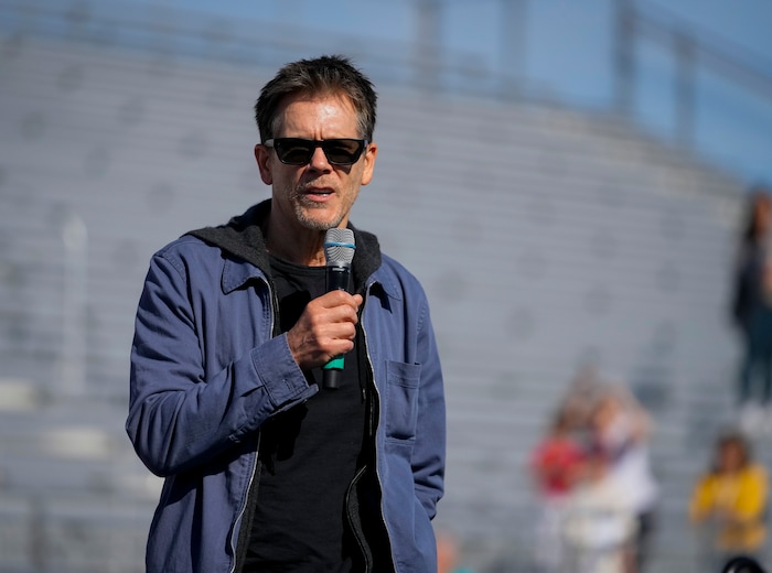 (Bethany Baker | The Salt Lake Tribune) Kevin Bacon speaks at a charity event to commemorate the 40th anniversary of the movie "Footloose" on the football field of Payson High School in Payson on Saturday, April 20, 2024.