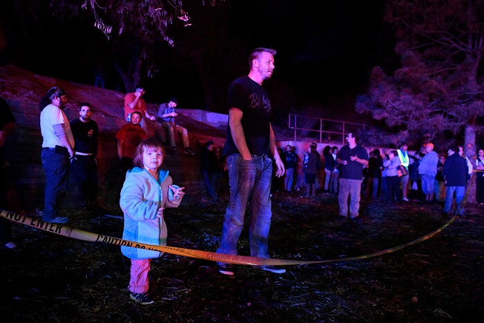 Walmart employees and customers that were inside the store wait to hear what to do from police as they stand behind police tape outside of a Walmart store where several people were killed in a shooting, Wednesday, Nov. 1, 2017, in Thornton, Colo. Investigators, who have not released any details about the circumstances of the shooting, were reviewing security footage and interviewing witnesses to get a description of the shooter. (Helen H. Richardson/The Denver Post via AP)