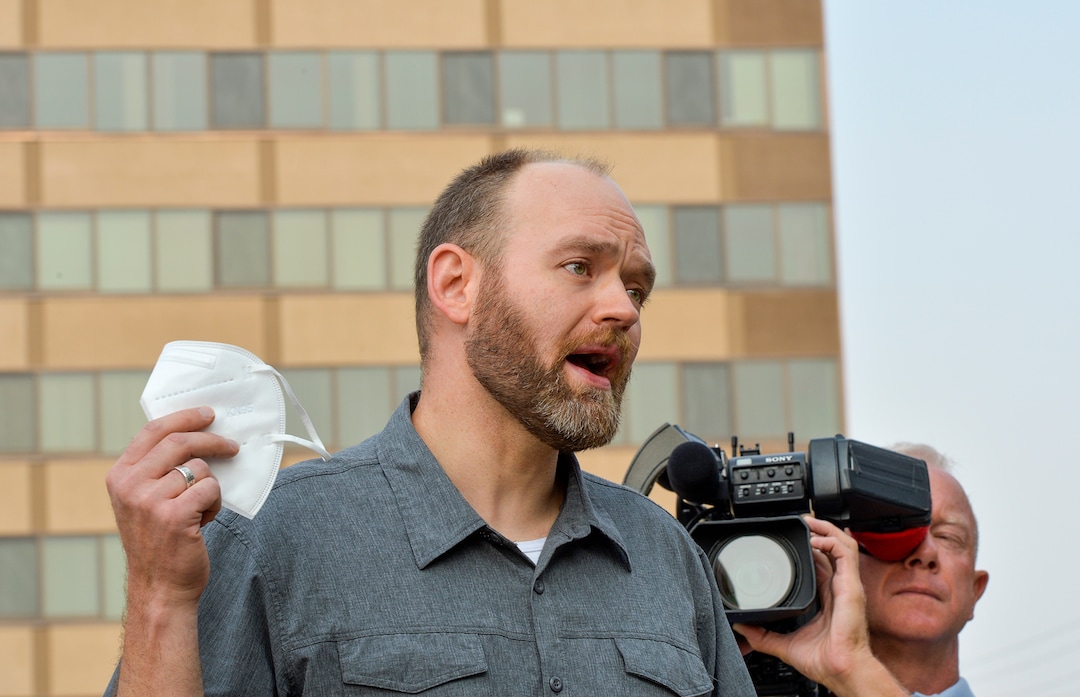 (Chris Samuels | The Salt Lake Tribune) Chris Phillips holds a mask as he speaks at a rally advocating mask use in schools outside the Utah Board of Education building, Friday, Aug. 6, 2021.