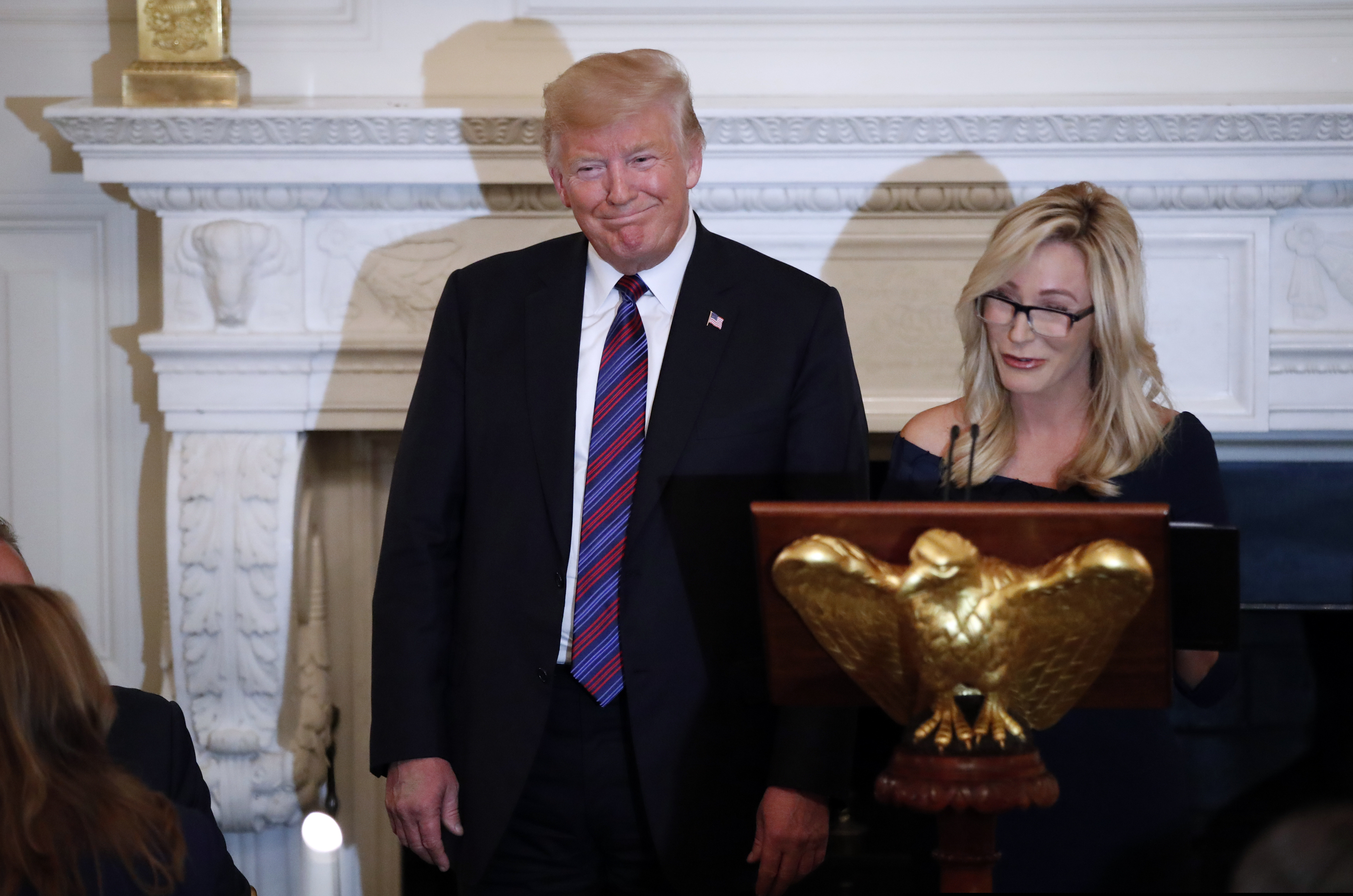 (Alex Brandon | AP file photo) In this Aug. 27, 2018, file photo, President Donald Trump smiles as Pastor Paula White prepares to lead the room in prayer, during a dinner for evangelical leaders in the State Dining Room of the White House. White, now has a formal role in the administration with the Public Liaison office, which oversees outreach to constituent groups seen as key parts of the president’s base. The move giving the Florida-based, tele-evangelist an administration job is seen as another step to solidify his evangelical base as his reelection bid ramps up.