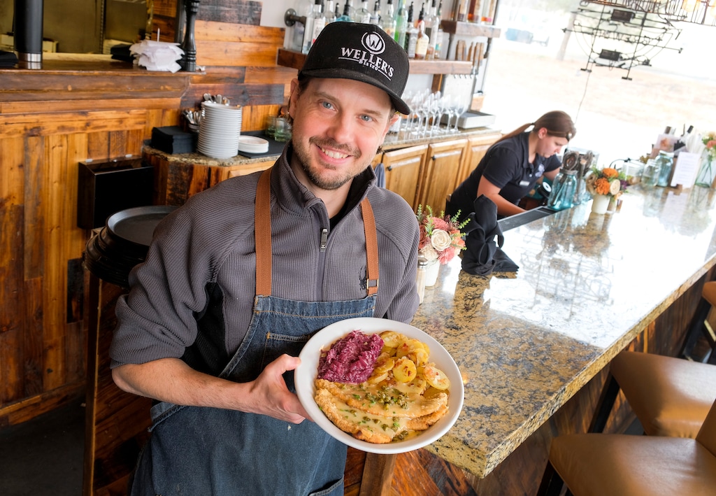 (Leah Hogsten | The Salt Lake Tribune) Jan Weller, owner and chef at Weller's Bistro in Layton, holds a plate of his famous schnitzel: parmesan crusted pork loin, served with lemon caper beurre blanc, rotkohl and bratkartoffeln.