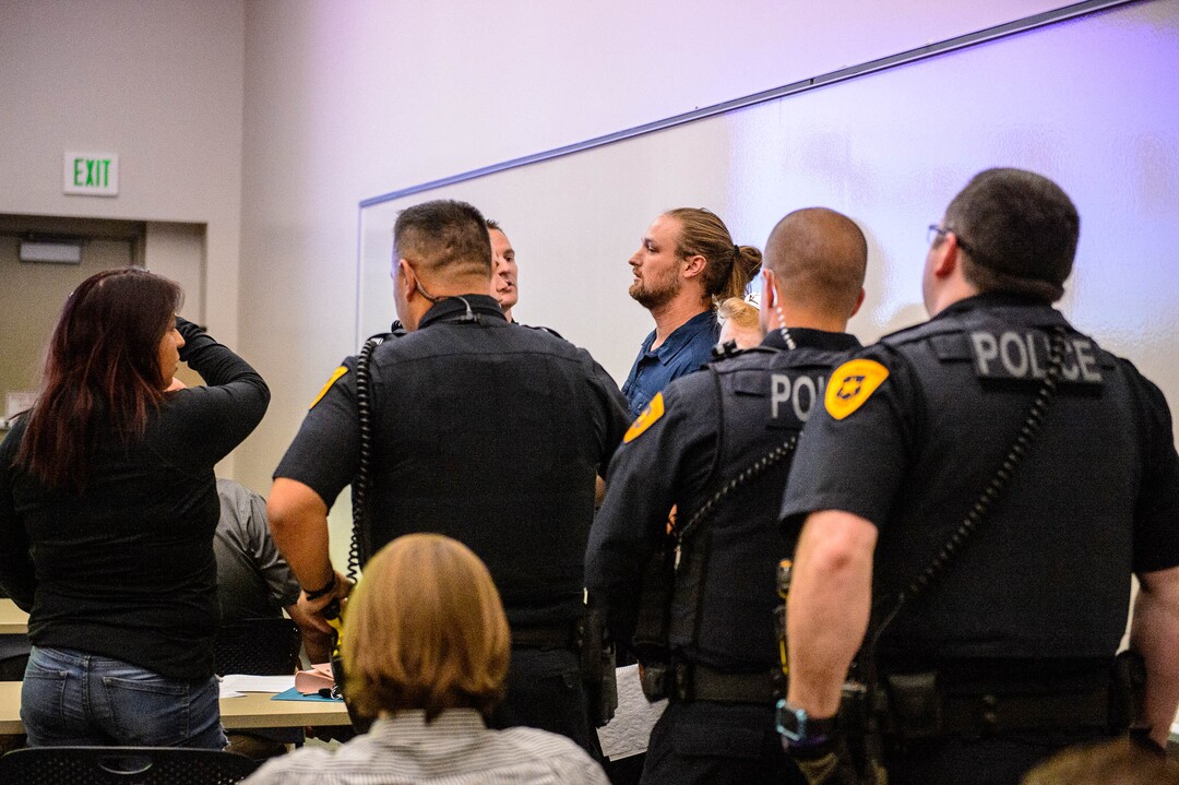 (Trent Nelson  |  The Salt Lake Tribune)  Ethan Peterson argues with police who are removing him from a meeting of an inland port satellite working group (which was quickly canceled), held at a police precinct in Salt Lake City on Wednesday Aug. 14, 2019.