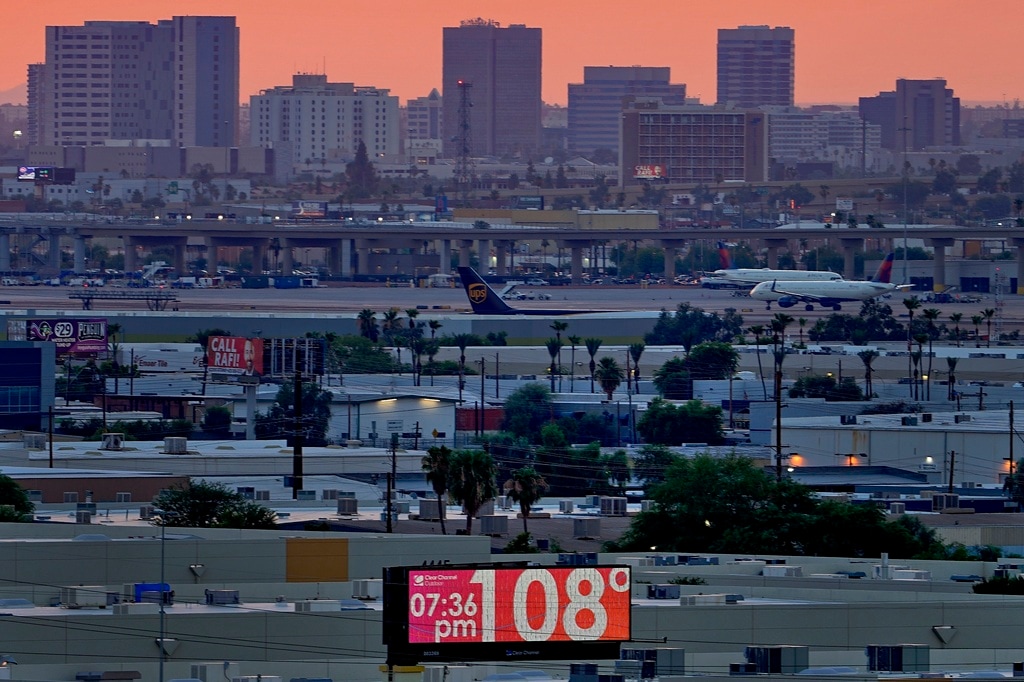(Matt York | AP) A sign displays an an unofficial temperature as jets taxi at Sky Harbor International Airport at dusk, July 12, 2023, in Phoenix. A new study Tuesday, July 25, finds these intense and deadly hot spells gripping much of the globe in the American Southwest and Southern Europe could not have occurred without climate change.