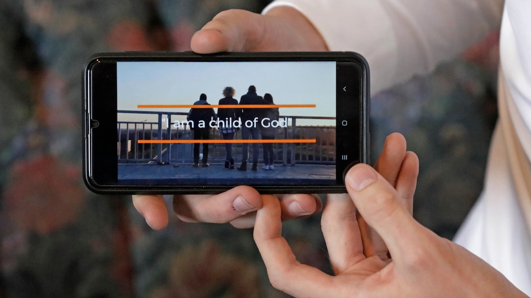 In this May 27, 2020, photo, from Seth Rather, a missionary with The Church of Jesus Christ of Latter-day Saints, looks at his smart phone at his apartment, in Brigham City, Utah. After hastily bringing home 26,000 young men and women who were serving in foreign countries, the faith has begun sending many of them out again in their home countries with a new focus on online work that could stick even when the pandemic is over, church officials told The Associated Press. For safety reasons missionaries are now inside and on their smartphones most of the day trying to find new converts or bolster the faith of current church members. (AP Photo/Rick Bowmer)