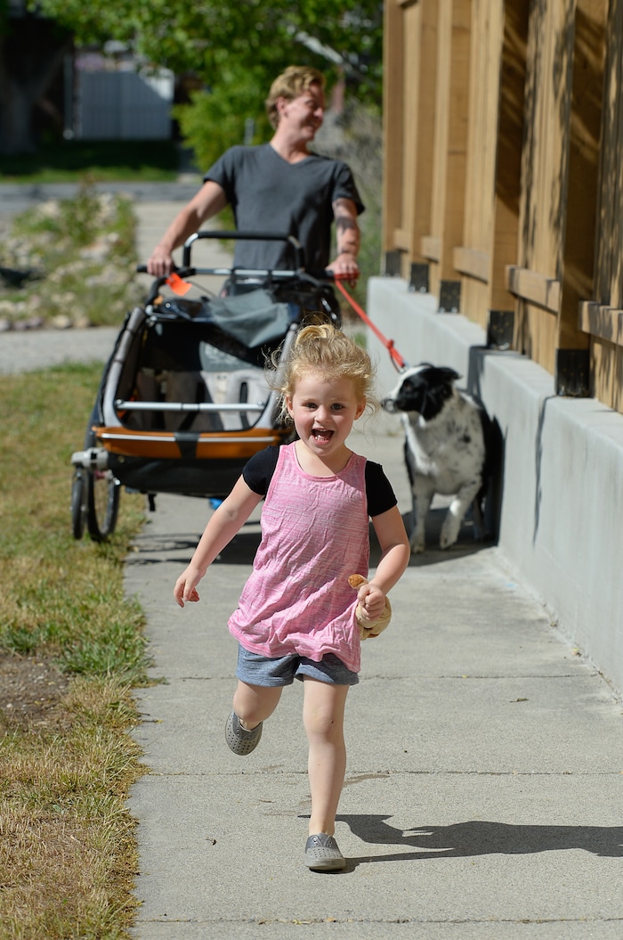 (Francisco Kjolseth | The Salt Lake Tribune) Scott Allen holds on to Veya the family dog as he tries to keep up with his free spirited daughter Audrey, 3, on their way to a gymnastics class recently. Scott and his Wife Rachel, both anesthesiologists in a burn unit are trying to balance a free range childhood with safety practices to prevent their kids experiencing the injuries they witness at work every day. Utah is believed to be the first state to pass a law that prevents parents from being prosecuted for allowing mature kids with good judgement to do things alone, provided they are otherwise cared for.