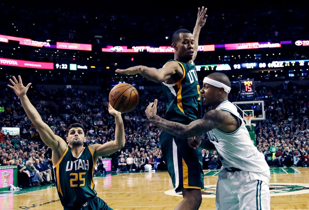 Boston Celtics guard Isaiah Thomas, right, passes the ball as he is pressured by Utah Jazz guards Rodney Hood, center, and Raul Neto (25), of Brazil, during the second half of an NBA basketball game in Boston, Tuesday, Jan. 3, 2017. Thomas had 29 points and 15 assists as the Celtics defeated the Jazz 115-104. (AP Photo/Charles Krupa)