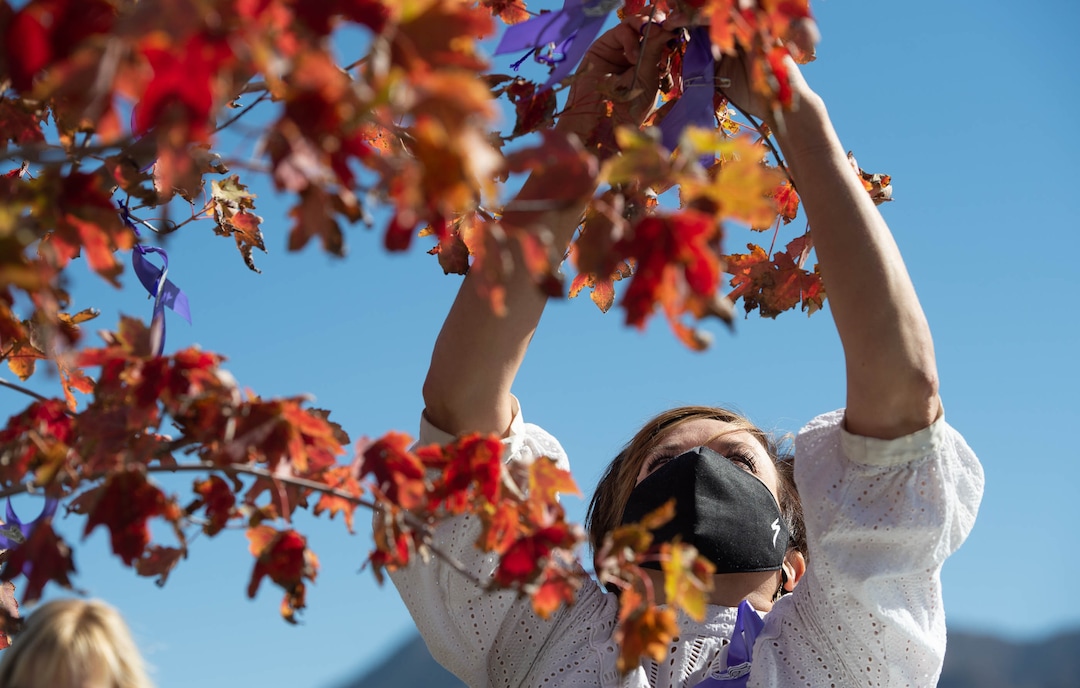 (Francisco Kjolseth  |  The Salt Lake Tribune) Aimee Stone, attaches purple ribbons to a tree that was planted in honor of University of Utah student and track athlete Lauren McCluskey on the two-year anniversary of her murder on Thursday, Oct. 22, 2020. Planted next to the track where she used to compete, friends, family and fellow student athletes gathered for a memorial walk to remember her.