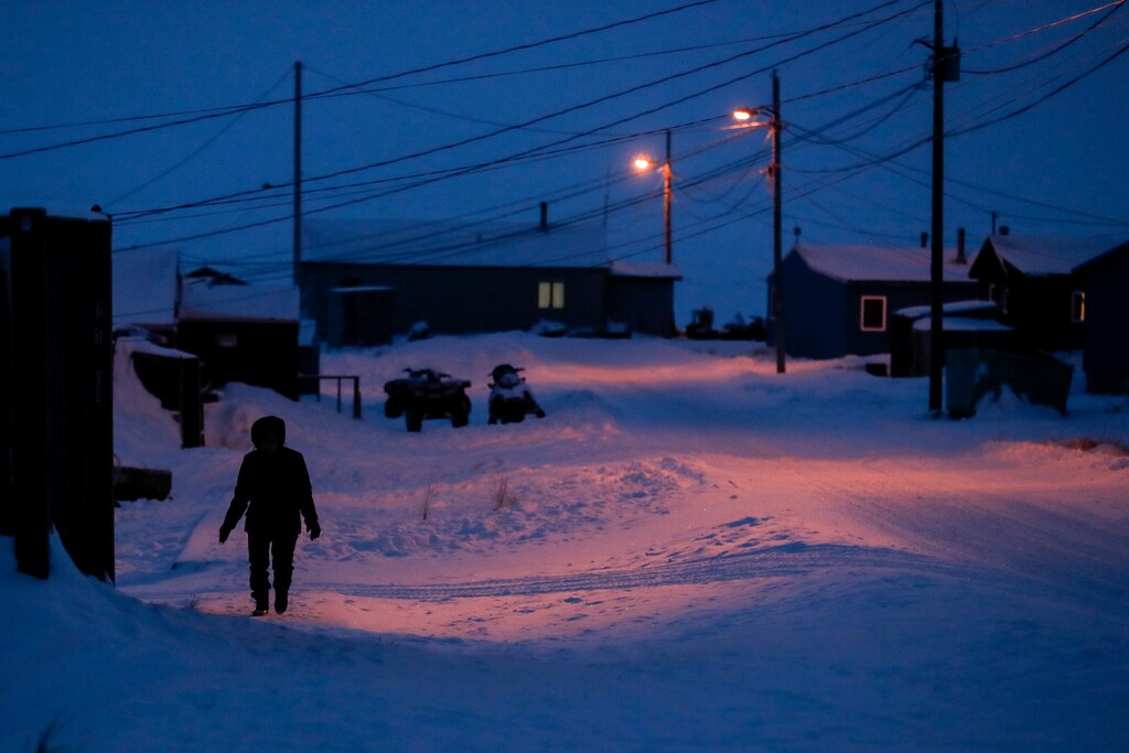 (Gregory Bull | AP) In this Jan. 20, 2020, file photo, a woman walks before dawn in Toksook Bay, Alaska, a mostly Yup'ik village on the edge of the Bering Sea. A judge has ruled in favor of tribal nations in their bid to keep Alaska Native corporations from getting a share of $8 billion in coronavirus relief funding — at least for now. In a decision issued late Monday, April 27, 2020, U.S. District Judge Amit Mehta in Washington, D.C., said the U.S. Treasury Department could begin disbursing funding to 574 federally recognized tribes to respond to the coronavirus but not to the corporations.