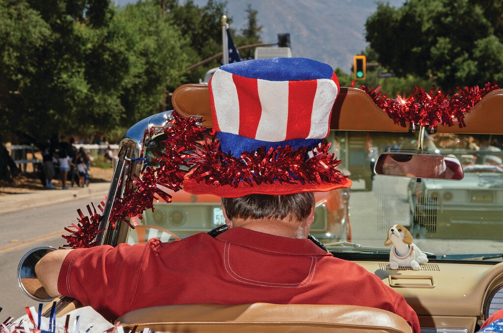 A man wearing a U.S. flag-themed hat drives through Ojai, Calif., on July 3, 2025. (Clara Mokri/The New York Times)