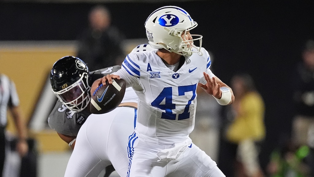 Brigham Young quarterback Bear Bachmeier, front, passes the ball as Colorado defensive tackle Tavian Coleman pursues in the first half of an NCAA college football game Saturday, Sept. 27, 2025, in Boulder, Colo. (AP Photo/David Zalubowski)