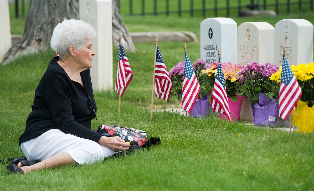 (Rick Egan  |  The Salt Lake Tribune)      Karen Keck, sit by the graves of her father, sister and brothers at the Fort Douglas Cemetery, after the Memorial Day observance Monday, May 28, 2018.