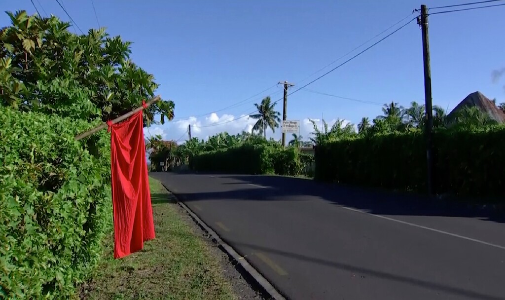 In this image from video, a red flag hangs outside homes of residents who have not been vaccinated in Apia, Samoa, Thursday, Dec. 5, 2019. Samoa’s main streets were eerily quiet on Thursday, as the government stepped up efforts to curb a measles epidemic that has killed 62 people. (TVNZ via AP)