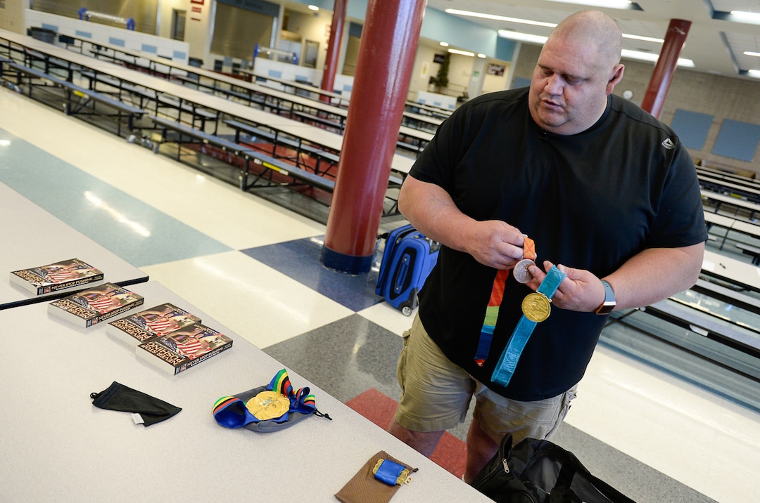 (Francisco Kjolseth  |  The Salt Lake Tribune)  Olympic wrestling champion Rulon Gardner displays his medals and his autobiography "Never Stop Pushing: My Life from a Wyoming Farm to the Olympics Medal Stand" as he meets with students and parents on Wed. May 16, 2018, to introduce himself as the new wrestling coach at Herriman High school. 