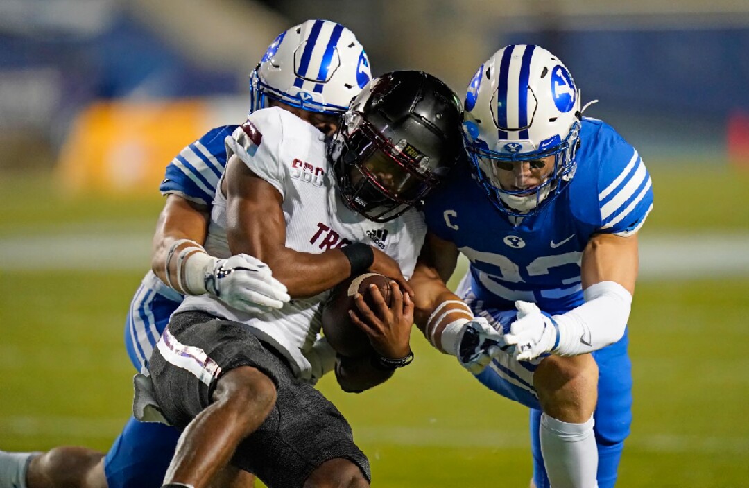Troy wide receiver Kaylon Geiger, center, is tackled by BYU linebacker Zayne Anderson (23) during the first half of an NCAA college football game Saturday, Sept. 26, 2020, in Provo, Utah. (AP Photo/Rick Bowmer, Pool)