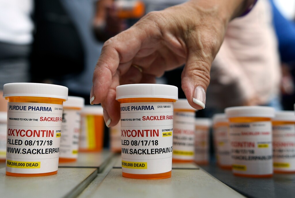 (Jessica Hill | AP file photo) In this Aug. 17, 2018, file photo, family and friends who have lost loved ones to OxyContin and opioid overdoses leave pill bottles in protest outside the headquarters of Purdue Pharma, which is owned by the Sackler family, in Stamford, Conn.