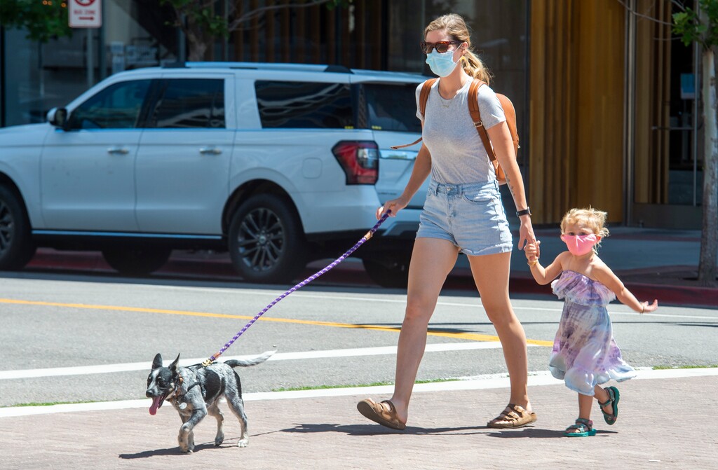 (Rick Egan | The Salt Lake Tribune) Mary Kendall Hegland wears a mask as she walks on Main Street with her daughter Brecken and her dog Boone in downtown Salt Lake City on Friday, June 26, 2020.