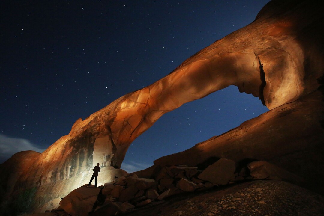 (Francisco Kjolseth | The Salt Lake Tribune) Will Prettyman, 11, has fun playing the role of assistant as he lights up Skyline Arch next to the Arches National Park campground in late May.