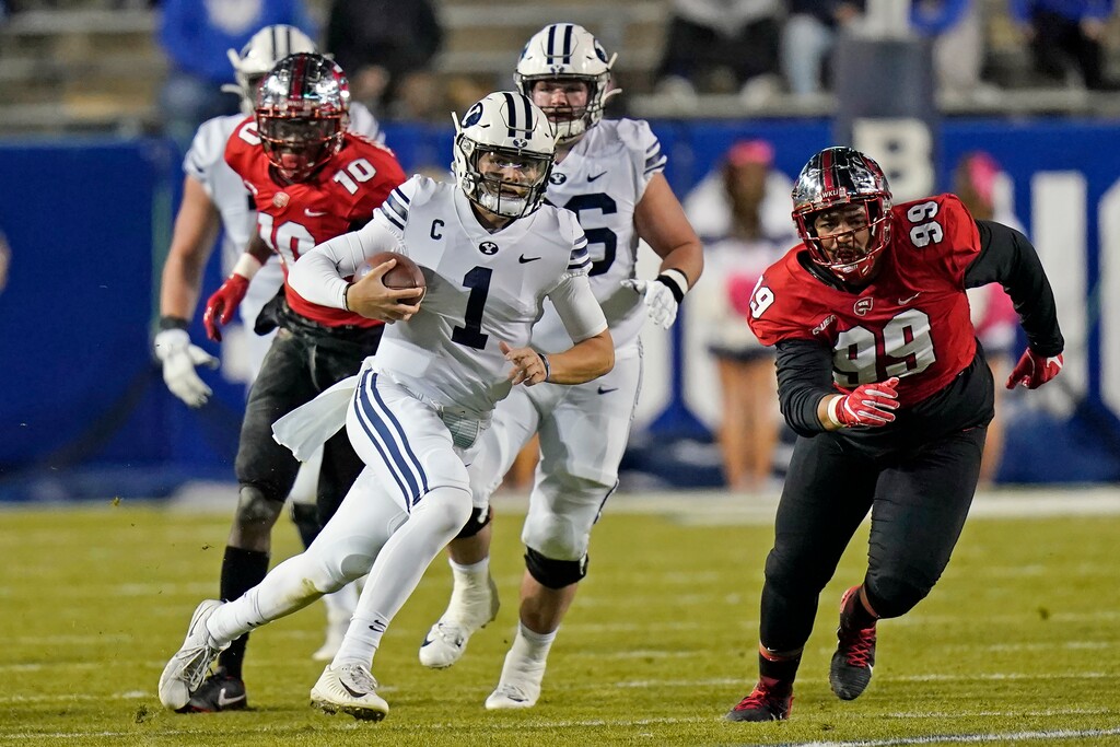 FILE - In this Saturday, Oct. 31, 2020, file pool photo, BYU quarterback Zach Wilson (1) carries the ball in the first half of an NCAA college football game against Western Kentucky in Provo, Utah. An unusual college football season has produced some unexpected unbeaten teams dotting the AP Top 25 with about a month left. Led by No. 7  Cincinnati and No. 8 BYU, five teams from outside the Power Five conferences have yet to lose. (AP Photo/Rick Bowmer, Pool, File)