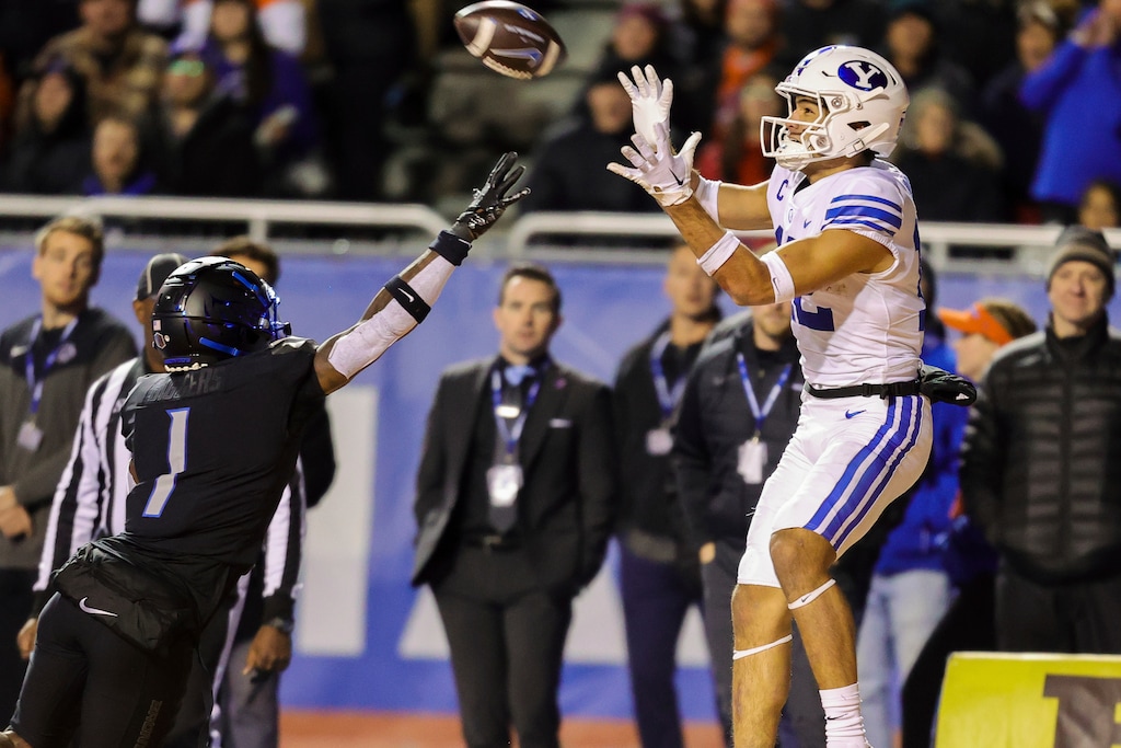 (Steve Conner | AP) BYU wide receiver Puka Nacua (12) reaches for the ball over Boise State cornerback Caleb Biggers (1) for a 24-yard touchdown reception in the second half, Saturday, Nov. 5, 2022, in Boise, Idaho.