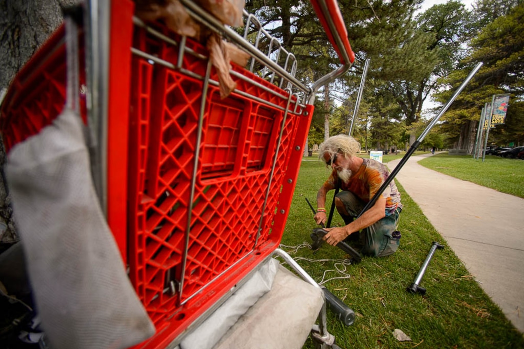 (Trent Nelson | The Salt Lake Tribune)  
Wolf, who is homeless, sets up a stand to sell tie-dye t-shirts in Salt Lake City's Liberty Park, Wednesday July 11, 2018. Wolf prefers to camp in various places around the city rather than stay in one of the available shelters because of drugs and other problems associated with those facilities.