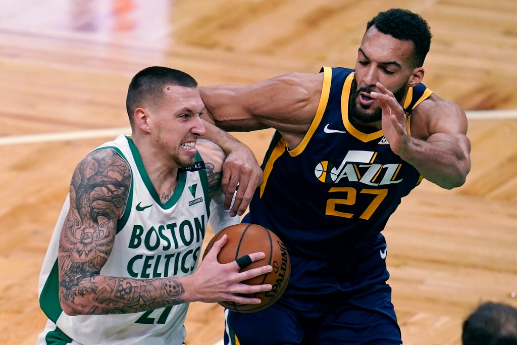 Boston Celtics center Daniel Theis, left, drives to the basket against Utah Jazz center Rudy Gobert, right, during the first half of an NBA basketball game, Tuesday, March 16, 2021, in Boston. (AP Photo/Charles Krupa)