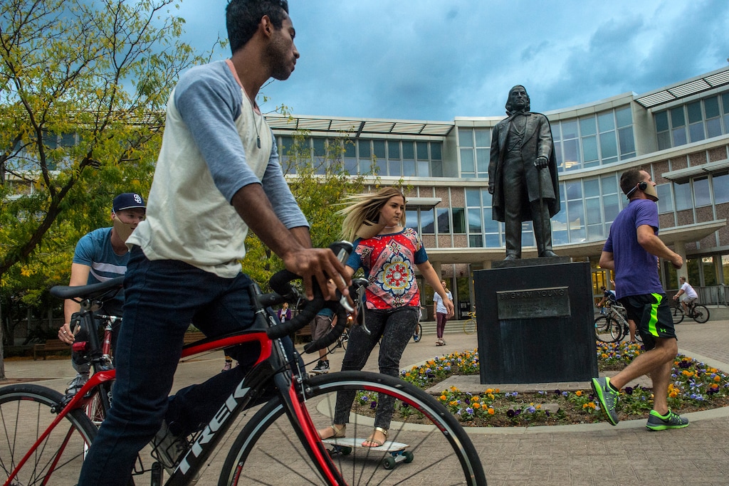 (Chris Detrick  |  The Salt Lake Tribune) In this file photo, students ride bikes and skateboards around a statue of Brigham Young outside of the Abraham O. Smoot Administration Building at BYU.