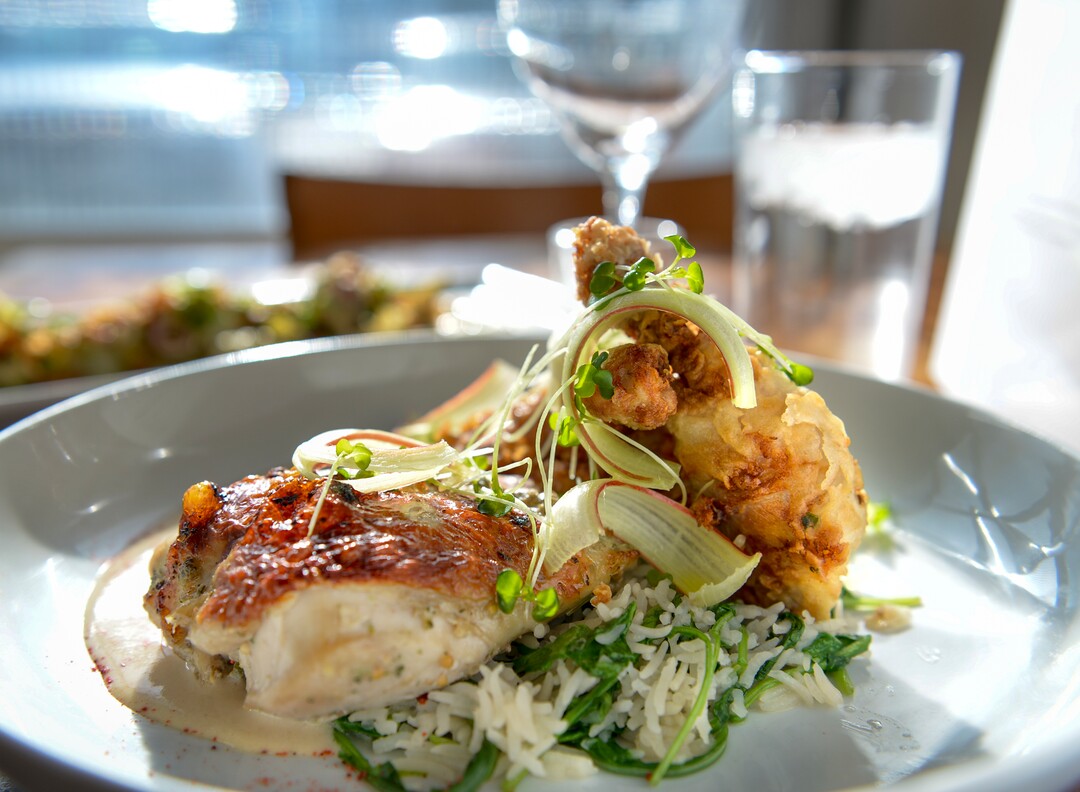 Leah Hogsten  |  The Salt Lake Tribune  SLC Eatery's roasted petite hen serves up a crispy thigh, rice, greens, rhubarb-amaretto glaze and almond-buttermilk, $24. SLC Eatery's regular menu and the cart offerings include globally inspired flavors of Latin America, the Mediterranean and Asia.