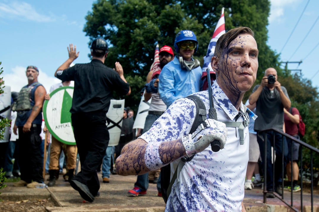 Protesters stands guard in front of the entrance to their gathering during a white nationalist rally, on Saturday Aug. 12, 2017, in Charlottesville, Va. The group had gathered to protest plans by the city of Charlottesville to remove a statue of Confederate Gen. Robert E. Lee. (Shaban Athuman /Richmond Times-Dispatch via AP)