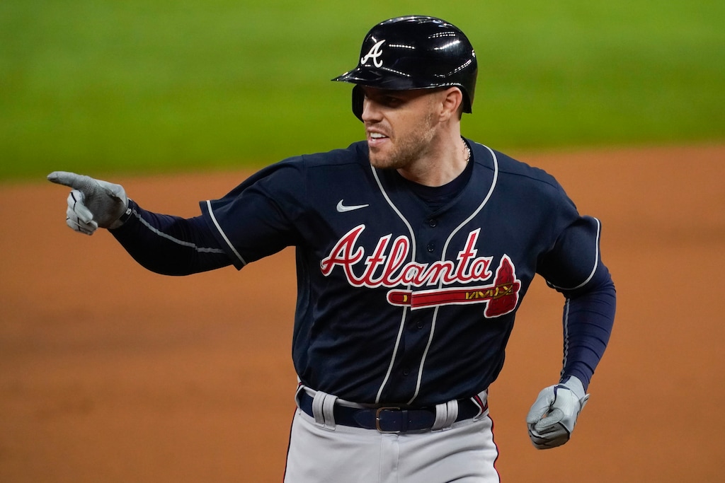 Atlanta Braves' Freddie Freeman points after a home run during the first inning in Game 1 of a baseball National League Championship Series against the Los Angeles Dodgers Monday, Oct. 12, 2020, in Arlington, Texas.(AP Photo/Tony Gutierrez)