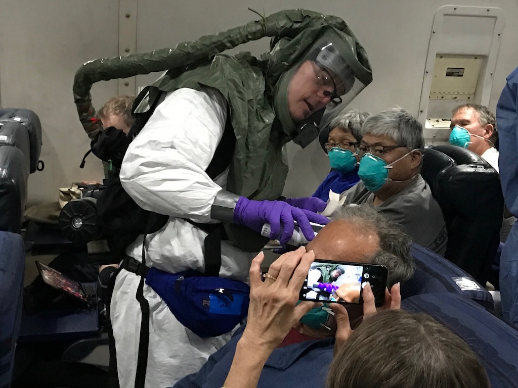 (Philip Courter via The New York Times) A photo provided by Philip Courter shows a temperature check aboard one of the charter flights carrying Americans who were evacuated from the Diamond Princess cruise ship in Japan back to the U.S. on Monday, Feb. 17, 2020. The U.S. Embassy in Tokyo had said that cruise ship passengers carrying the coronavirus would not be allowed to board evacuation flights, but the decision was apparently reversed at the last minute.
