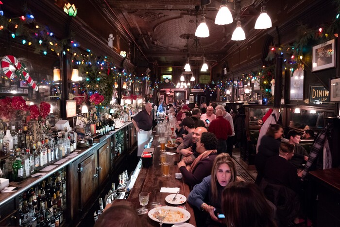 In this Dec. 27, 2019 photo, customers mingle in New York's Old Town Bar. Once a speakeasy during Prohibition, the Old Town Bar opened in 1892. In this era of bottomless mimosas, craft beers and ever-present happy hours, it’s striking to recall that 100 years ago the United States imposed a nationwide ban on the production and sale of all types of alcohol. (AP Photo/Mark Lennihan)