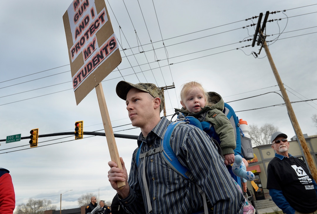 Scott Sommerdorf | The Salt Lake Tribune
David Woodward, a teacher at Ascent Academy in Farmington, marched with his daughter as pro gun March Before Our Lives marchers rallied across the street from West High School, Saturday, March 24, 2018.