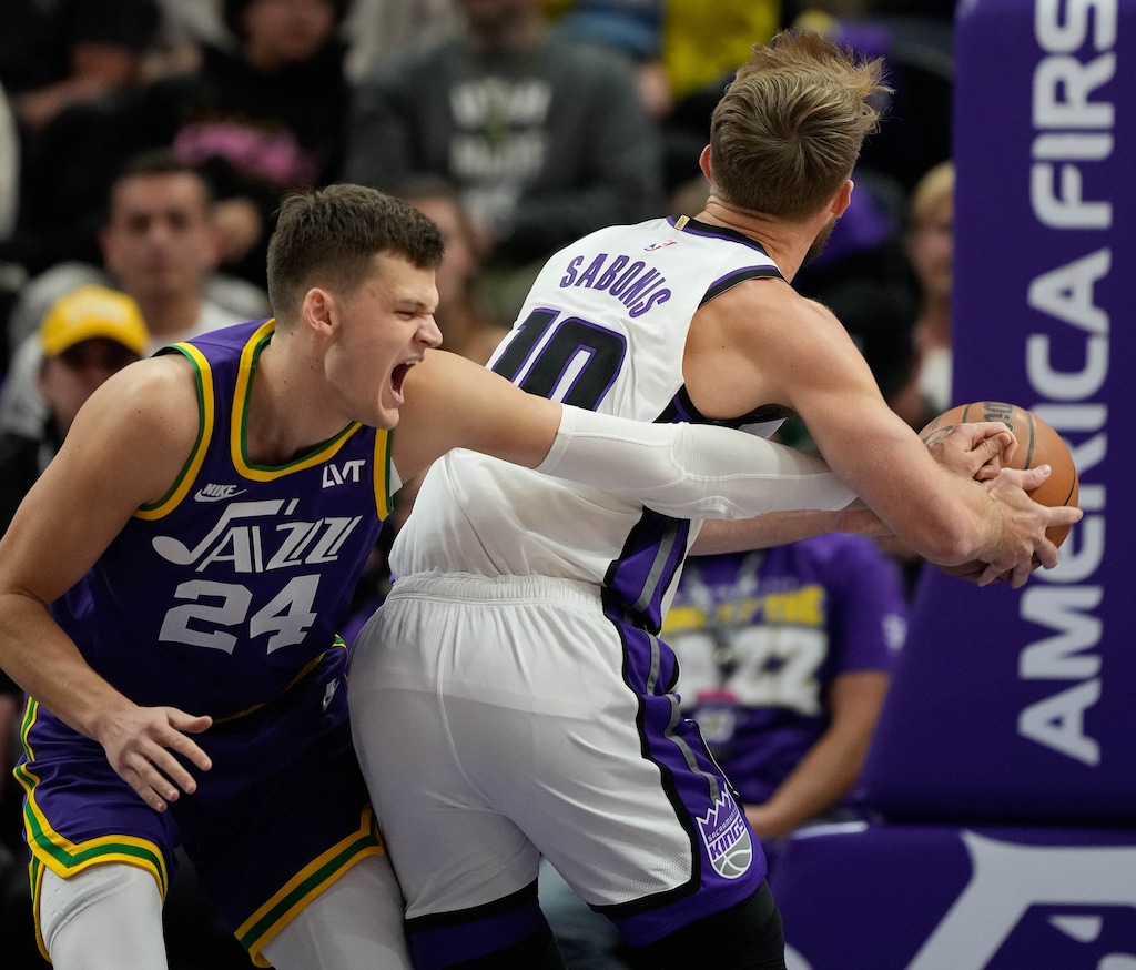 (Francisco Kjolseth | The Salt Lake Tribune) Utah Jazz center Walker Kessler (24) strains his elbow caught by Sacramento Kings forward Domantas Sabonis (10) in the season's second minute as the Utah Jazz host the Sacramento Kings, during NBA basketball in Salt Lake City on Wednesday, Oct. 25, 2023.