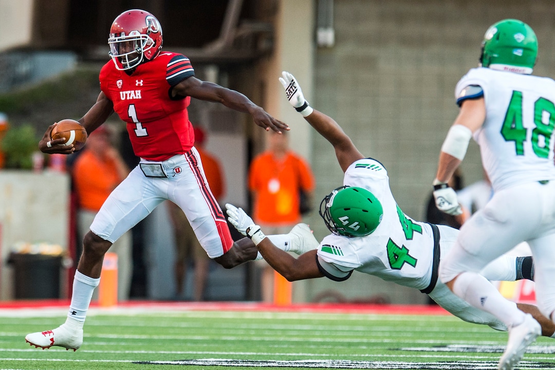 (Chris Detrick  |  The Salt Lake Tribune)  Utah Utes quarterback Tyler Huntley (1) runs past North Dakota Fighting Hawks linebacker Donnell Rodgers (44) during the game at Rice-Eccles Stadium Thursday, August 31, 2017. Utah Utes are leading North Dakota Fighting Hawks 17-9 at halftime. 