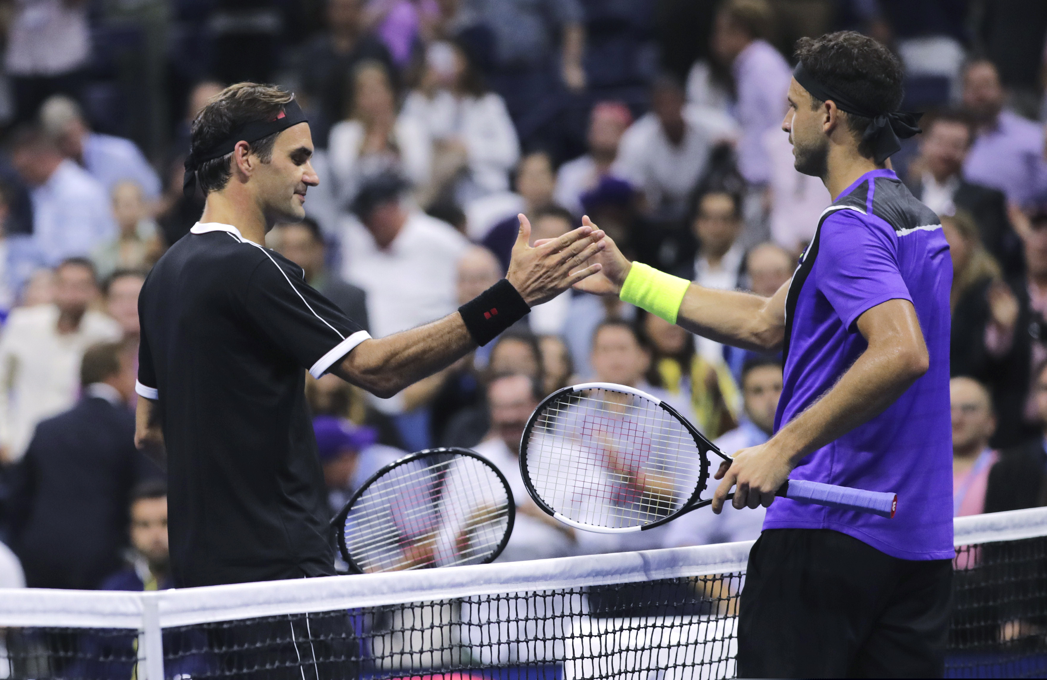 Grigor Dimitrov, of Bulgaria, right, shakes hands with Roger Federer, of Switzerland, after a quarterfinal of the U.S. Open tennis tournament Tuesday, Sept. 3, 2019, in New York. Dimitrov won 3-6, 6-4, 6-3, 6-4, 6-2. (AP Photo/Charles Krupa)