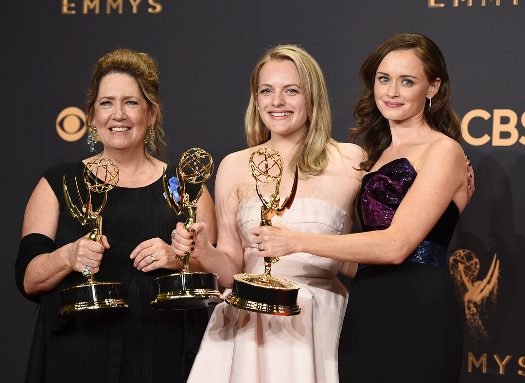 FILE - In this Sept. 17, 2017 file photo, Ann Dowd, from left, winner of outstanding supporting actress in a drama series, Elisabeth Moss, winner of outstanding lead actress in a drama series, and Alexis Bledel, winner of outstanding guest actress in a drama for "The Handmaid's Tale" pose in the press room at the 69th Primetime Emmy Awards at the Microsoft Theater in Los Angeles. The Nielsen company, which has long measured viewership of television programs, announced Wednesday, Oct. 18, says it has a way to collect and widely spread details about how many people watch programming produced by streaming services.  (Photo by Jordan Strauss/Invision/AP, File)