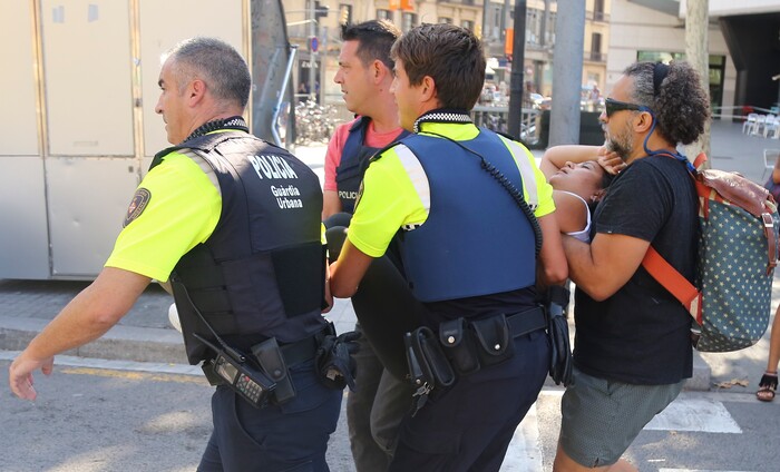 A woman is carried in Barcelona, Spain, Thursday, Aug. 17, 2017 after a white van jumped the sidewalk in the historic Las Ramblas district, crashing into a summer crowd of residents and tourists and injuring several people, police said. (AP Photo/Oriol Duran)