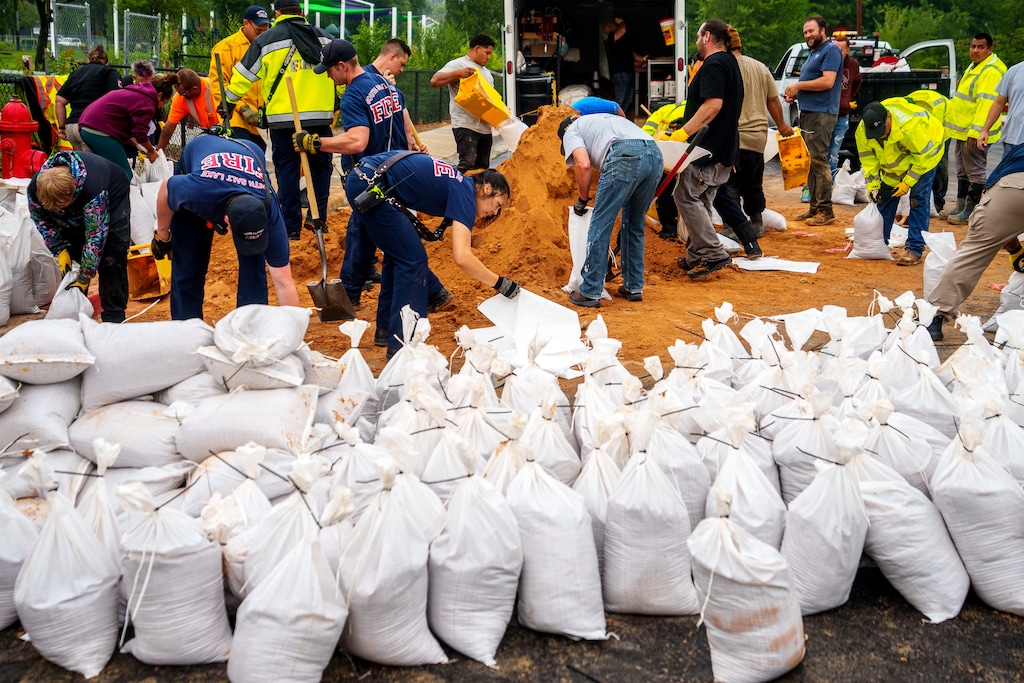 (Trent Nelson  |  The Salt Lake Tribune) Firefighters, public works employees, and volunteers fill sandbags in South Salt Lake after heavy rains on Wednesday, Aug. 18, 2021.