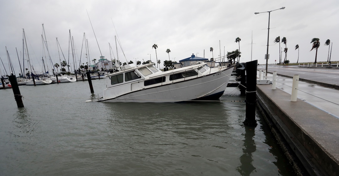 (Eric Gay | The Associated Press) A fishing boat is left partial submerged after Hurricane Harvey swept through the area, Saturday, Aug. 26, 2017, in Corpus Christi, Texas. Harvey has been further downgraded to a Category 1 hurricane as it churns slowly inland from the Texas Gulf Coast, already depositing more than 9 inches of rain in South Texas.
