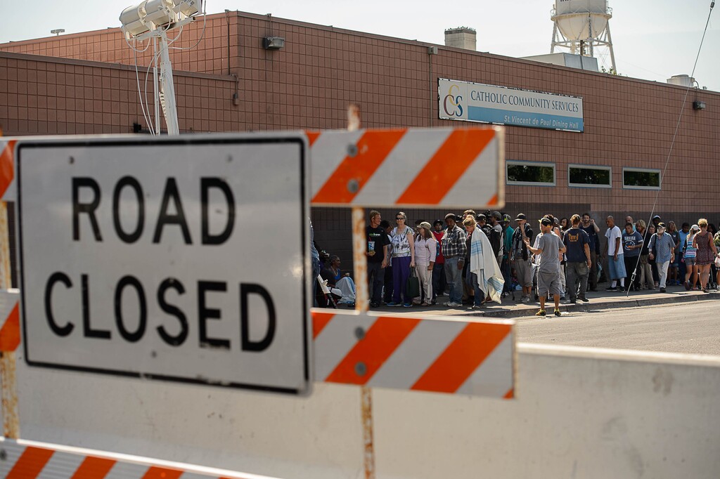 (Trent Nelson | The Salt Lake Tribune)  Needy people line up for lunch as workers install barriers on Rio Grande in Salt Lake City to prevent auto traffic in hopes of stopping the drug traffic around the area, Friday September 1, 2017.