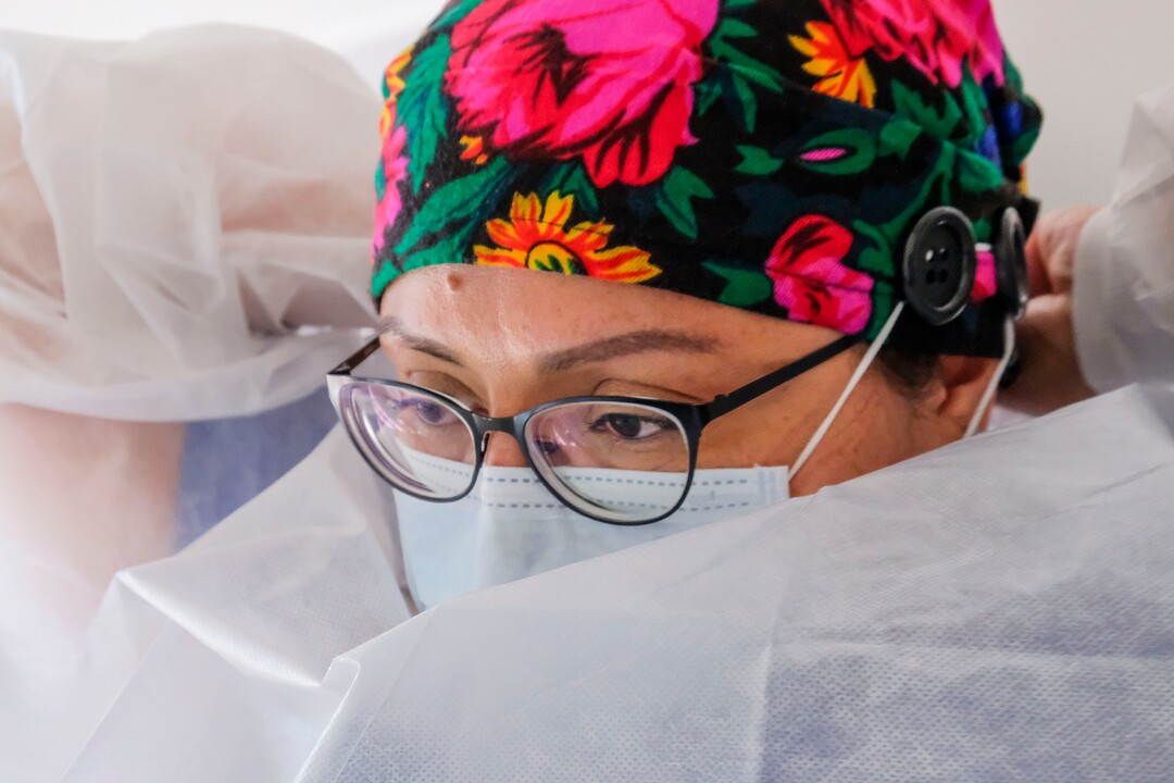 (Leah Hogsten  |  The Salt Lake Tribune) Navajo Mountain Health Clinic medical assistant Toni Black suits up in personal protective equipment or PPE, while tending to a 74-year-old Diné patient, Aug., 25, 2020. Black is extra cautious and now wears three layers of latex gloves since the UNHS clinic had to close down in June for two weeks after a staff member tested positive for COVID-19.