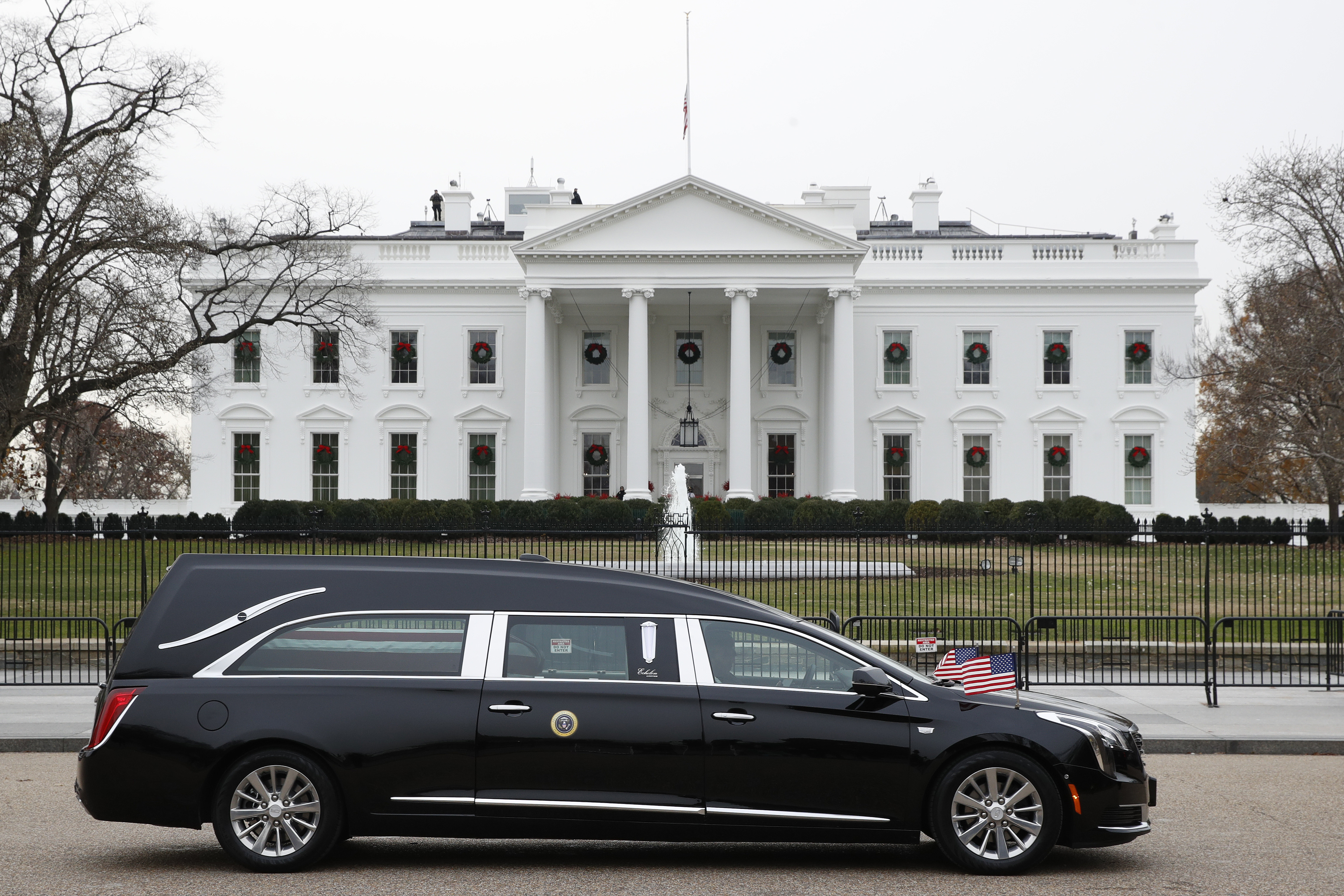 The hearse carrying the flag-draped casket of former President George H.W. Bush passes by the White House from the Capitol, heading to a State Funeral at the National Cathedral, Wednesday, Dec. 5, 2018, in Washington. AP Photo/Jacquelyn Martin).