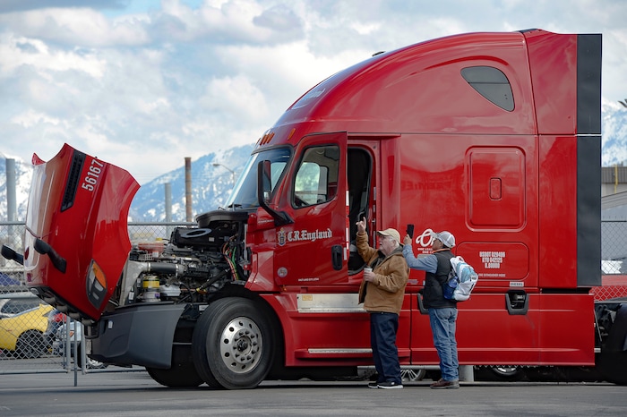(Francisco Kjolseth | The Salt Lake Tribune) A driver and co-driver inspect a rig at C.R. England trucking in Salt Lake City on Monday, March 30, 2020. The coronavirus outbreak has helped make truckers heroes as they help to stock empty shelves in stores. Drivers face new challenges from finding restrooms and food on the road amid shutdowns, but say they enjoy driving with no congestion.
