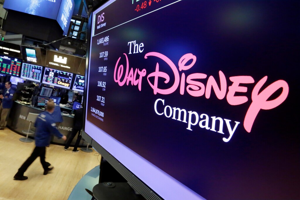 FILE - In this Aug. 8, 2017, file photo, The Walt Disney Co. logo appears on a screen above the floor of the New York Stock Exchange. Disney is buying a large part of the Murdoch family's 21st Century Fox in a $52.4 billion deal, announced Thursday, Dec. 14, including film and television studios, cable and international TV businesses as it tries to meet competition from technology companies in the entertainment business. (AP Photo/Richard Drew, File)