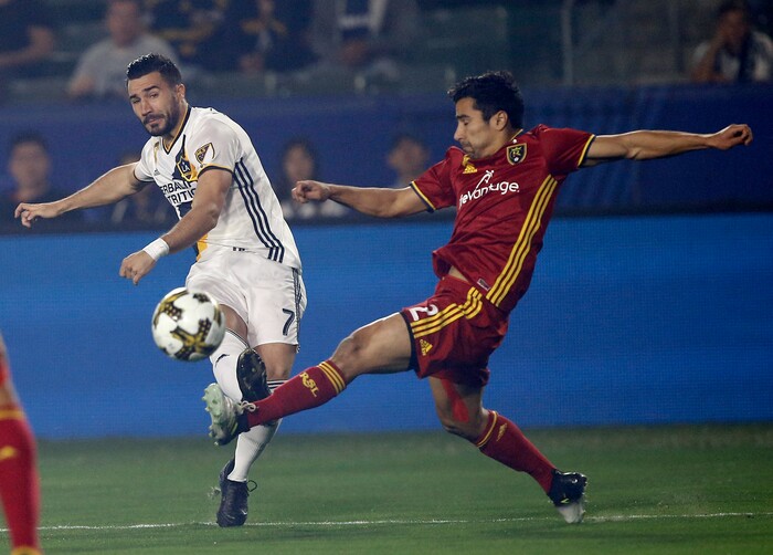 Los Angeles Galaxy midfielder Romain Alessandrini, left, shoots over Real Salt Lake defender Tony Beltran during the first half of an MLS soccer game in Carson, Calif., Saturday, Sept. 30, 2017. (AP Photo/Alex Gallardo)