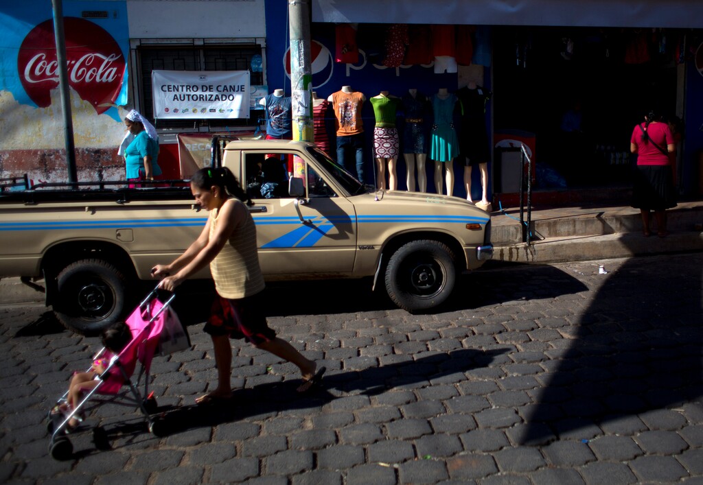 (Rebecca Blackwell | The Associated Press) In this Aug. 18, 2018 photo, people walk past a general store in Intipuca, El Salvador. In Intipuca, immigrating to the U.S., particularly Washington D.C., has been a way of life for 50 years, leaving many of its homes empty due to half the town's population living in Washington D.C.